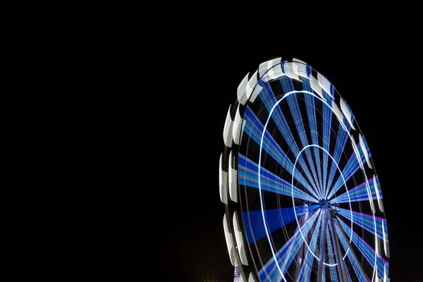 Longue exposition de la roue ferris éclairée la nuit — Photo