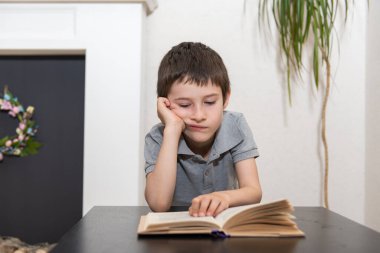 İlgisiz bir öğrenci kitap okur.