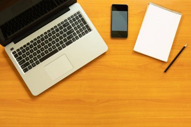 Teknoloji ve İletişim İş Konseptleri. Dizüstü bilgisayarın üst görüntüsü, akıllı telefon, not defteri, metin veya resim için fotokopi alanı olan kalem. Evde çalışıyorum..