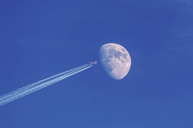 Arka plan olarak mavi gökyüzünde ay ile modern jet uçağı, hasta yapma