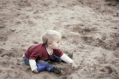 Mutlu bebek kız, Toddler, bir oyun üzerinde kum ile oynuyor.