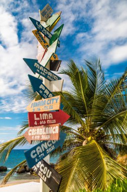 Directional sign on a Domincan beach clipart