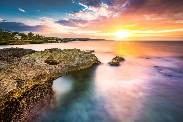 Sonnenuntergang über einem tropischen Felsstrand — Stockfoto