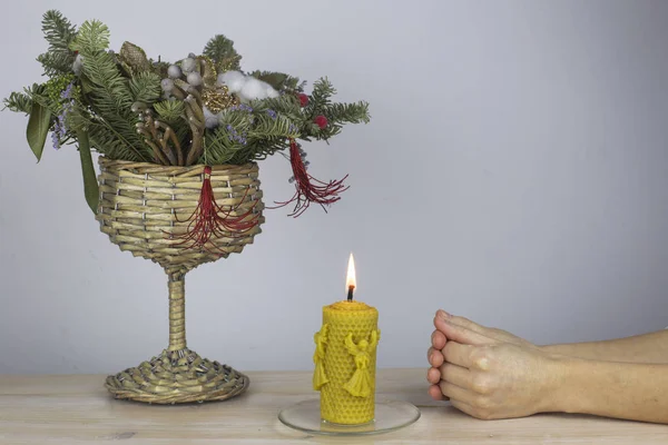 Christmas composition, wax candle and hands in prayer — Stock Photo, Image