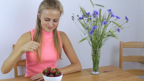 Девушка ест клубнику и показывает большой палец вверх — стоковое видео