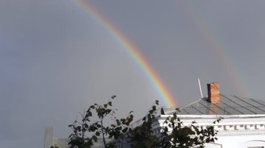 Bulutlar ve çatıda bir gökkuşağı