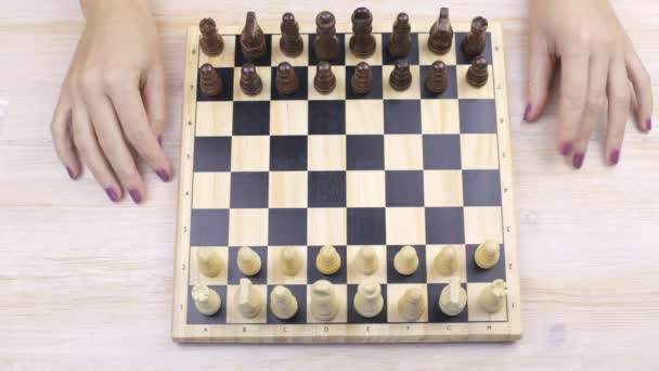 Les échecs et les mains féminines sur une table — Video