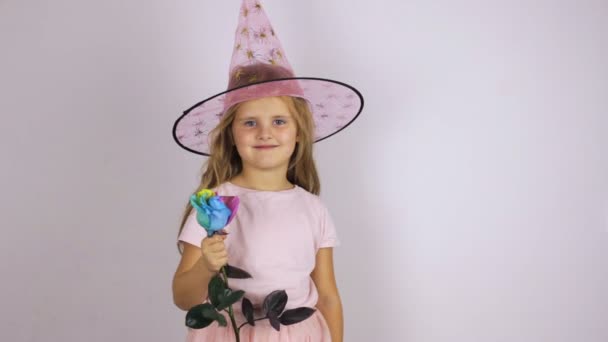 Девушка в карнавальной шляпе нюхает розу — стоковое видео