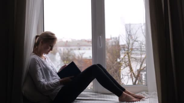 Lány ülve egy könyvet olvas — Stock videók