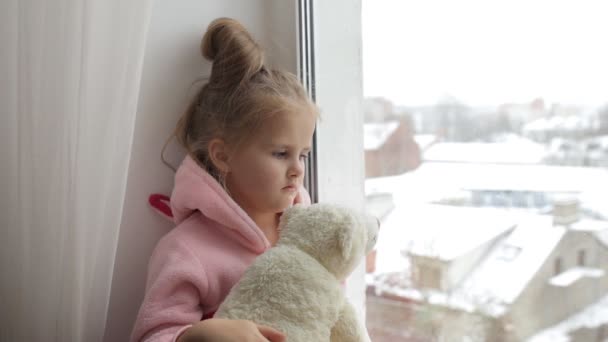 Девушка сидит и обнимает игрушечного медведя — стоковое видео