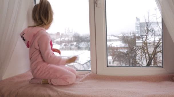 Pencere kenarında oturan küçük kız — Stok video