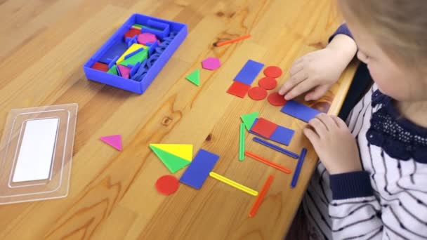 Niño recoge objetos de formas geométricas — Vídeo de stock