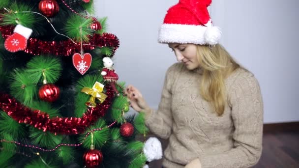A Mikulás sapka lány díszíti a karácsonyfát — Stock videók