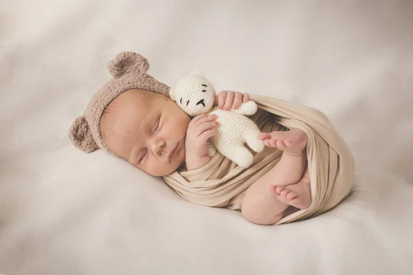 Recién nacido durmiendo chico con un juguete en un sombrero con orejas —  Fotos de Stock