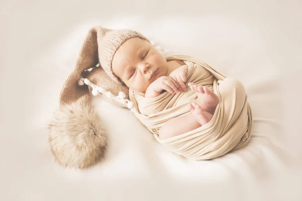 Recién nacido durmiendo chico en una gorra con un bubo —  Fotos de Stock