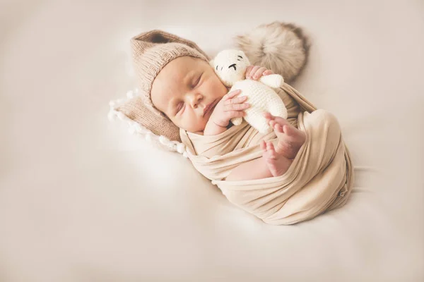Recién nacido durmiendo chico con un juguete sobre un fondo beige —  Fotos de Stock