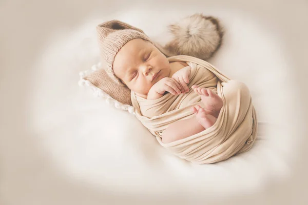 Niño recién nacido en el devanado sobre un fondo beige —  Fotos de Stock