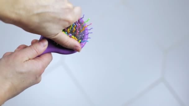 Female hands remove lost hair from a comb — Stock Video