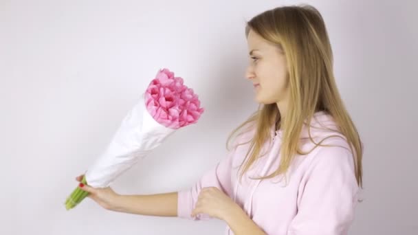 Женщина смотрит на букет розовых тюльпанов — стоковое видео