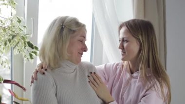 Anne ve kızı konuşuyor ve contentedly kucaklayan
