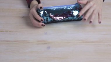 Kahverengi ve mavi kalem kutusu tutan eller