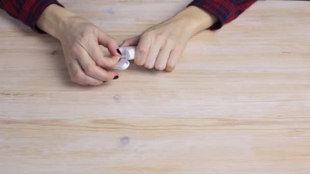 As mãos femininas com uma manicura abrem uma caixa com fio dental — Vídeo de Stock