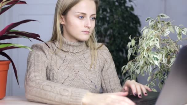 Fille est tapant à son ordinateur portable autour de beaucoup de plantes d'intérieur — Video