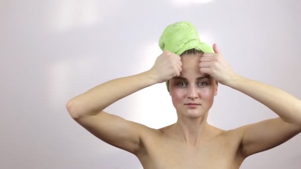 Menina com uma toalha na cabeça faz uma massagem facial — Vídeo de Stock