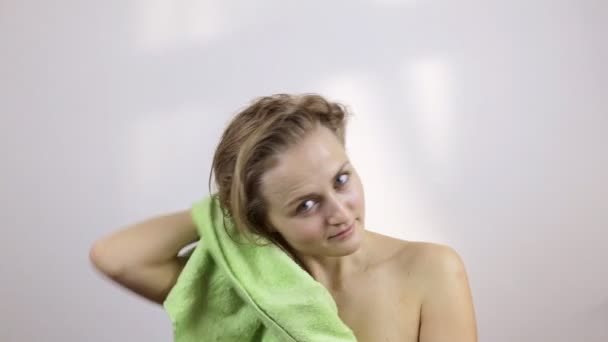Женщина вытирает волосы светло-зеленым полотенцем — стоковое видео