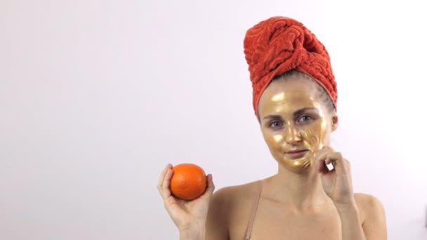 Женщина снимает с лица золотую маску — стоковое видео