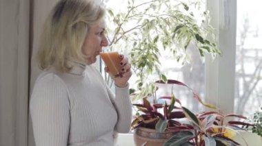 Pencereden dışarı bakarak ve suyu içme kadın