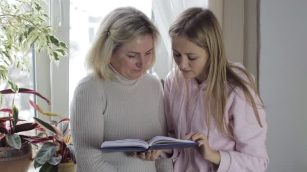 Frauen schauen in Notizbuch und besprechen etwas — Stockvideo