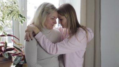 Anne ve kızı kucaklayan ve üzgün