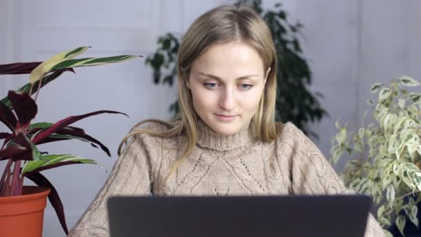 Chica en casa sentado y trabajando en un ordenador portátil — Vídeo de stock