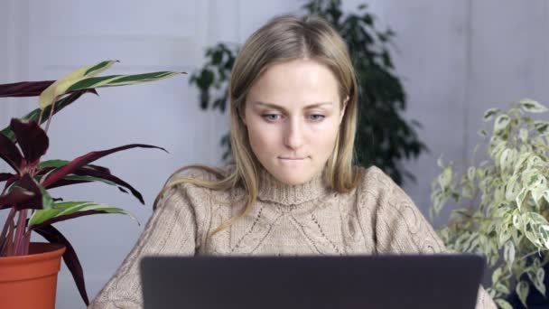 Jeune femme en vêtements de maison se trouve derrière un ordinateur portable et montre tout à fait pouces vers le haut — Video