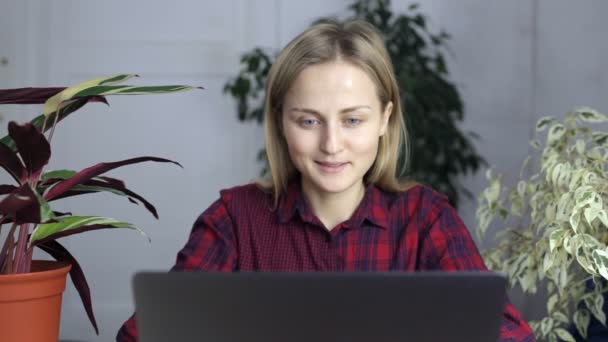 Приваблива дівчина працює на ноутбуці вдома — стокове відео