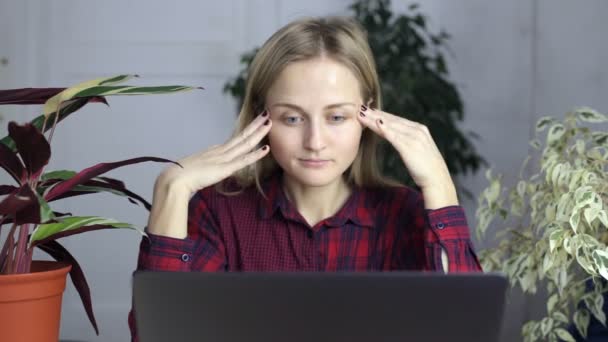 Trött kvinna, massera hennes huvud, lindra stress från långa timmar av arbete och tittar på en laptop skärm. — Stockvideo