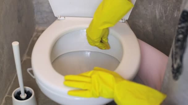 Woman with rubber glove cleans the toilet with a sponge — Stock Video