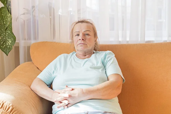 Genç büyükanne oturur ve dikkatlice uzaktan bakar.