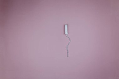Kirli pembe arka plan üzerinde adet sırasında kadın beyaz tampon