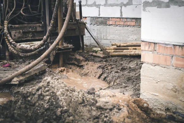 Kuyular için matkap yeni bir evin inşaatı yakınında çalışır