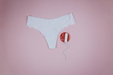 Kırmızı bir sinyal ve beyaz bir bez ile pembe bir arka plan üzerinde Kadın külot