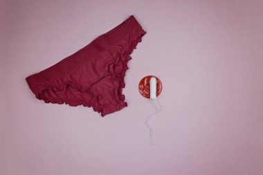 Pembe arka plan üzerinde tampon ile kırmızı külot