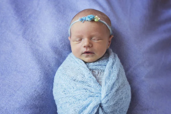 Una niña recién nacida está durmiendo en un devanado azul con una corona en la cabeza —  Fotos de Stock