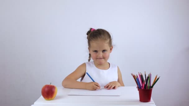 Niña preescolar riendo sentada en un escritorio — Vídeos de Stock