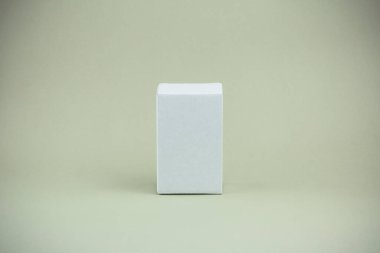 Gri zeytinli arka planda beyaz küçük karton kutu. Arkaplan