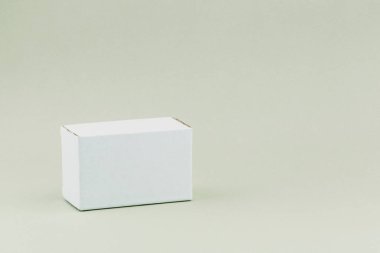 Arka planda beyaz, küçük bir karton kutu. Arkaplan