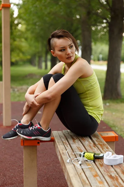 Young woman in sport wear at street workout area