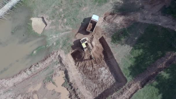 空中无人机拍摄的挖掘机装载地球到一个小卡车 — 图库视频影像