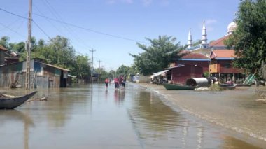 Kampong / Kamboçya / Ağustos 2017: Müslüman kadınlar beyaz camiye yakın sular altında köy yürürken